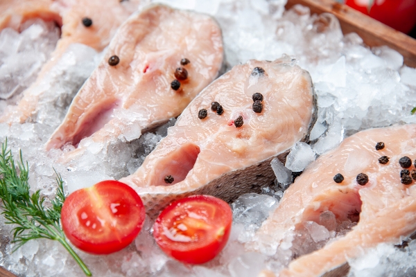 close up view raw fish slices with ice tomato slices - Кнели из судака с маслом