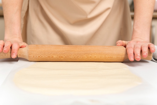 cook rolls out the dough thinly with rolling pin process of making roll - Постные лепёшки с зеленью (кутабы)