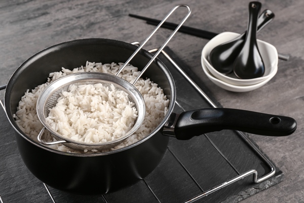 cooked rice in saucepan with sifter on grate - Начинка из сушёных грибов с рисом и луком