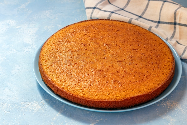 freshly baked uncut carrot pie lemon tart or semolina cake on blue plate - Морковно-творожный мазурек