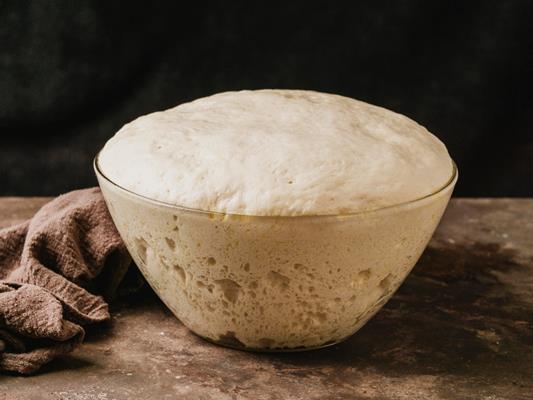 high angle of bowl with growing dough for pizza - Кулич быстрый с лимоном и ванилином