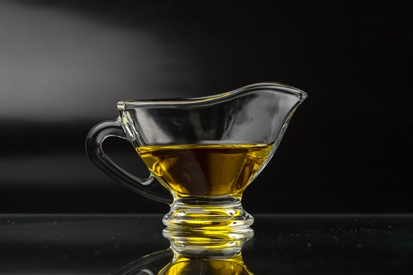 olive oil in a glass gravy boat on a black surface - Жаворонки простые