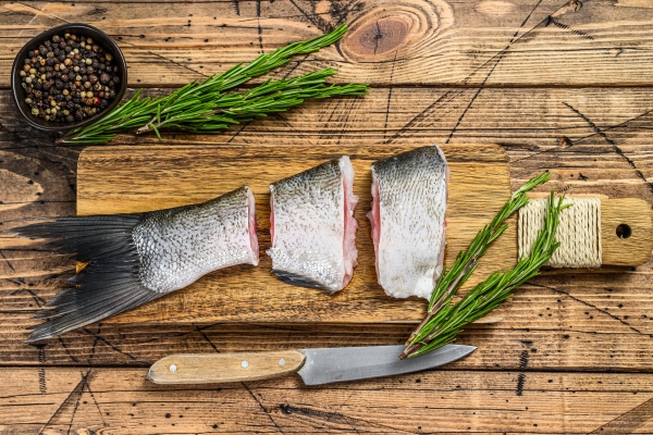 raw fish silver carp sliced into steaks wooden background top view - Карп по-краковски