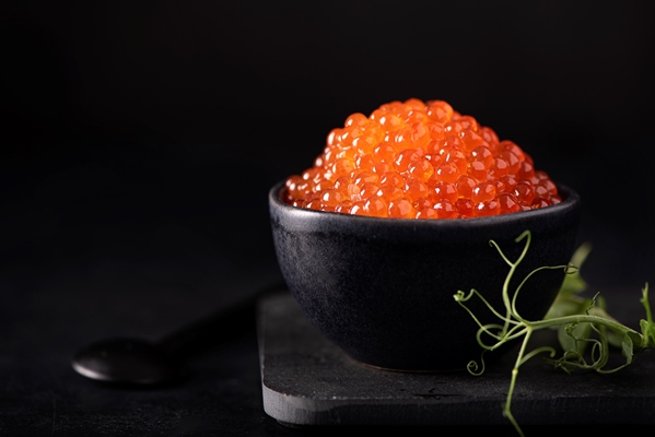 red salmon caviar in a small black bowl - Икорный паштет постный