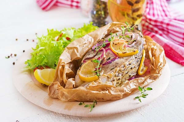 white fish steak carp baked in parchment paper with vegetables fish dish - Карп по-краковски