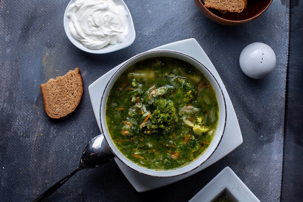 a top view green borsh vegetable soup along with sour cream and bread - Греческий суп с одуванчиками