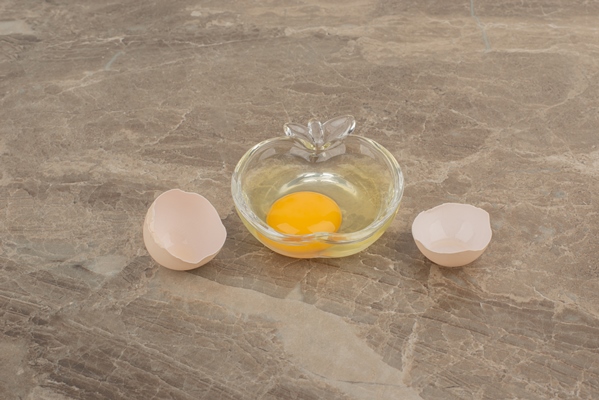 broken egg on plate on marble table - Лебеда с яйцом по-азербайджански