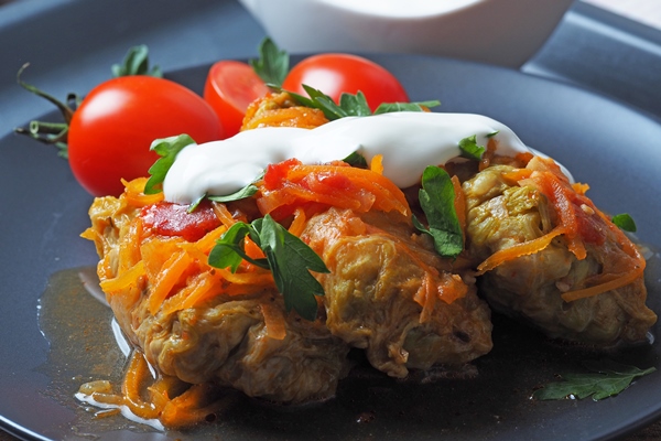 cabbage rolls with meat rice and vegetables stuffed peking cabbage leaves with meat in tomato sauce on a black plate chow farchi dolma sarma cabbage rolls or golabki top view - Голубцы из листьев лопуха мясные