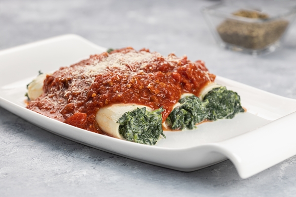 closeup shot of a cannelloni dish stuffed with spinach and ricotta served with bolognese sauce 1 - Каннеллони со снытью и соусом болоньезе