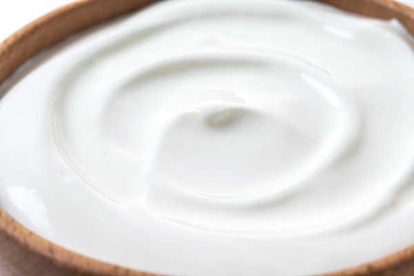greek yogurt in wooden bowl isolated on white background - Рулетики из сныти с творогом