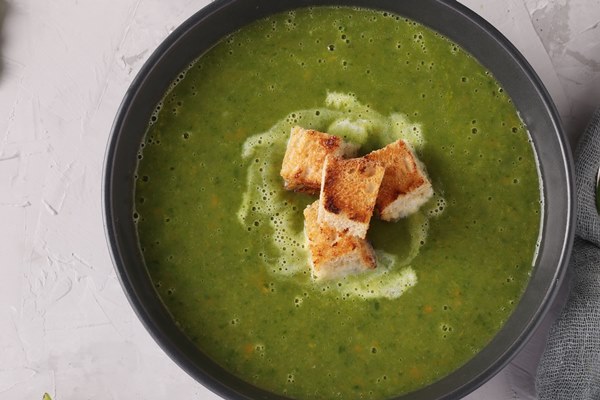 green spinach puree soup served with croutons in a dark bowl on a gray concrete table top view space for text 1 - Суп из черемши