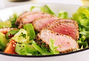 japanese traditional salad with pieces of medium rare grilled ahi tuna and sesame with fresh vegetable on a bowl - Тунец с салатом