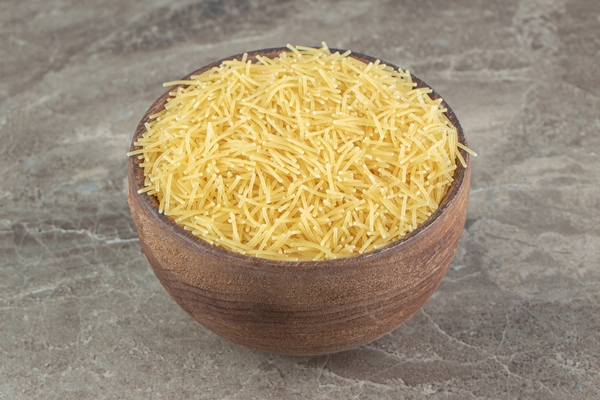 pile of uncooked vermicelli in wooden bowl - Запеканка с лебедой