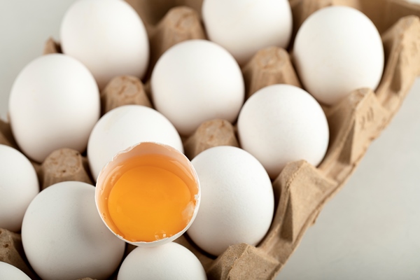 raw chicken eggs in egg box on a white surface - Голубцы с черемшой