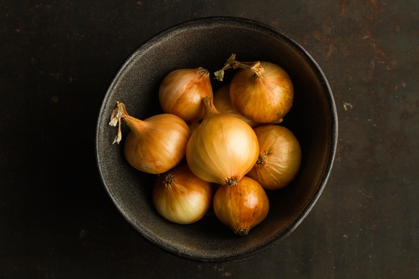 small white french onions in a dark bowl - Голубцы из листьев лопуха мясные