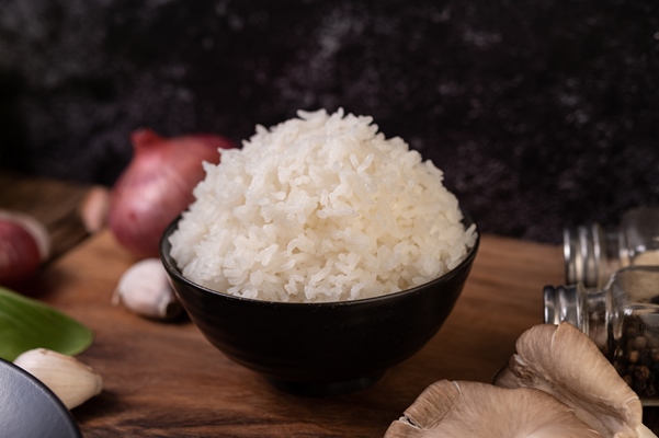steamed rice in a bowl with garlic and red onion on a wooden cutting board - Греческий суп с одуванчиками