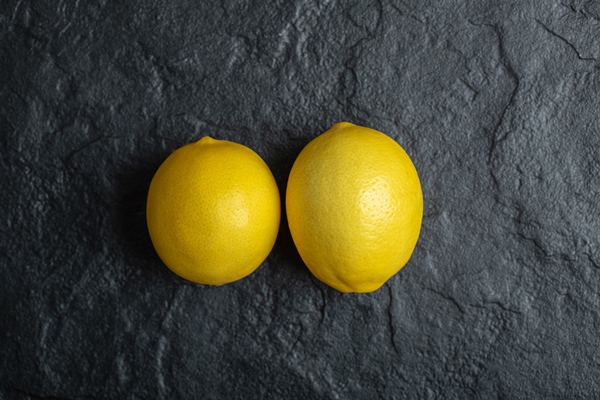 top view of two fresh ripe lemon on black background - Квас из одуванчиков