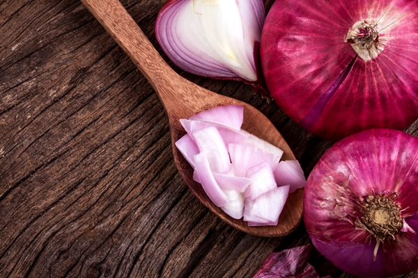 close up of the sliced red onion and whole bulb onion on a wooden background - Постные ленивые голубцы с грибами и рисом