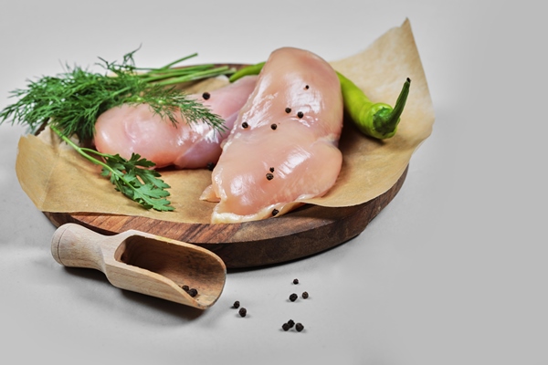raw chicken fillets on wooden plate with spoon - Куриное филе, запечённое по-французски