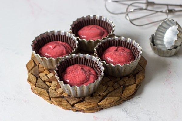 red velvet cupcake dough in form for baking on a white table - Капкейки "Красный бархат"