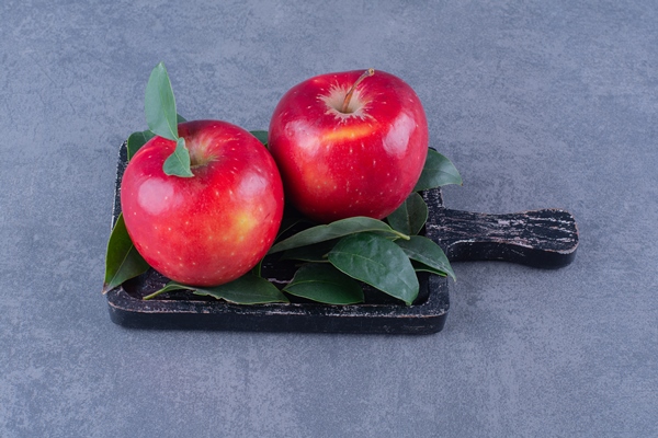 ripe apples with leaves on board on the dark surface - Яблоки в вине с розмарином и морковью