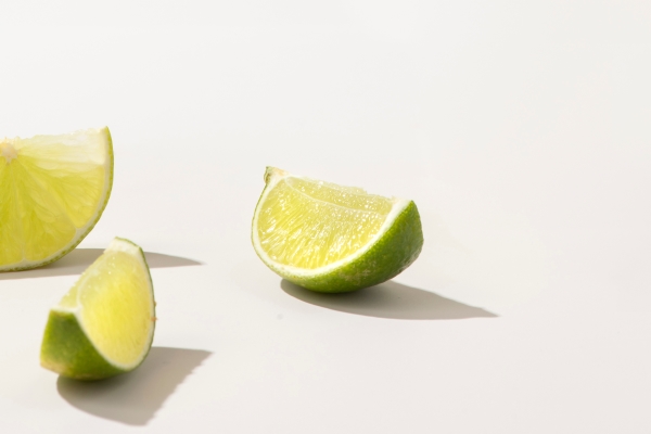 slices of fresh green lime on white table - Острый фруктовый салат
