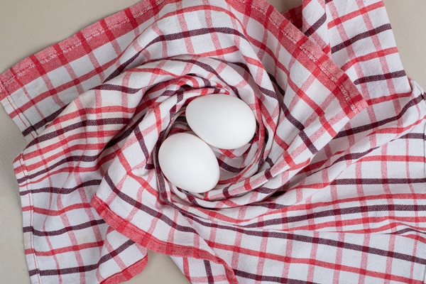 two fresh chicken white eggs on tablecloth - Архангельский салат из трески