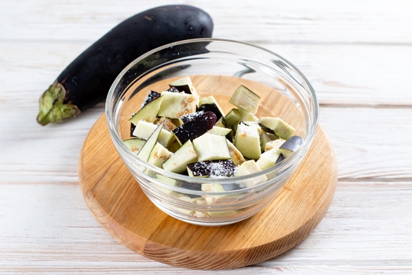 chopped eggplant in a glass bowl with salt bowl on table 2 - Драники из картофеля и баклажанов