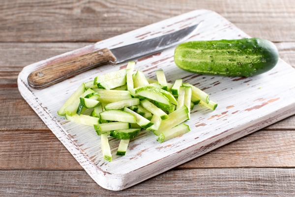 cucumber slices on a cutting board for making green beans salad step by step recipe - Салат из стручковой фасоли с курицей и огурцами