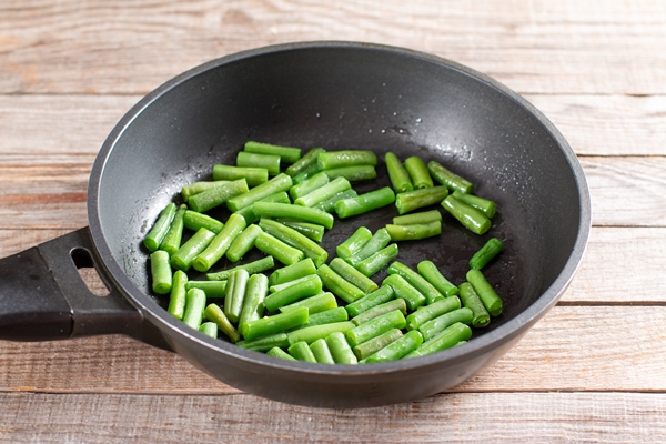 green beans in a skillet for preparing green beans salad step by step recipe healthy salad - Салат из стручковой фасоли с курицей и огурцами