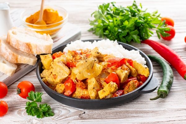 indian chicken curry or kadai chicken with rice in a frying pan on a wooden table - Курица карри (кадхай)
