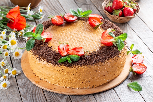 waffle cake with condensed milk cocoa and butter garnished with strawberries on a wooden table - Вафельный торт со сгущёнкой