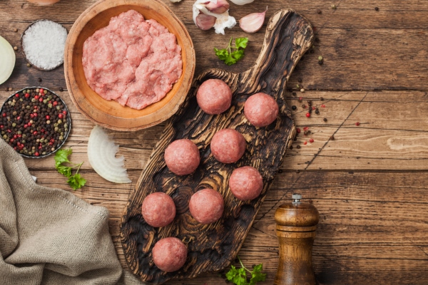 fresh beef raw meatballs on wooden board with mince on bowl plate with pepper salt and garlic on wooden background - Суп с фрикадельками, нутом и лапшой