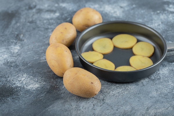 sliced potatoes inside of pan on grey background high quality photo - Мясо по-французски