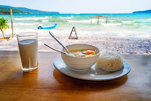 thai cuisine a plate of soup with coconut milk and boiled rice on the table against the beautiful sea landscape breakfast at the beach restaurant coast of island koh rong samloem cambodia - Растительное молоко: виды и свойства