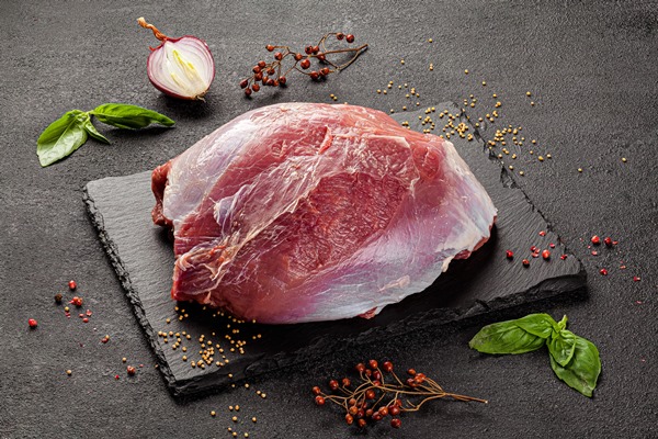 raw meat on a dark background - Свинина с каштанами и грибами