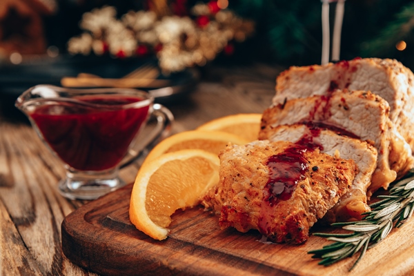 baked meat with lingonberry sauce and oranges on the christmas table - Клюквенный (или брусничный) взвар
