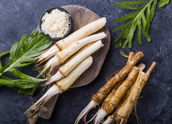 fresh orgaanic horseradish or horse radish root on wooden cutting board - Русский столовый хрен