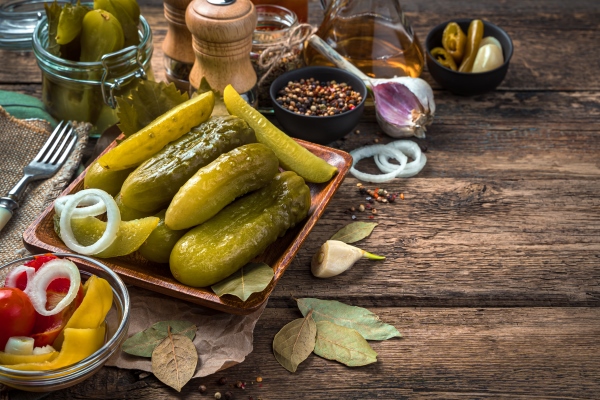pickled cucumbers garlic and bay leaf on a wooden background the concept of culinary backgrounds - Грибной суп с соленьями в горшочках