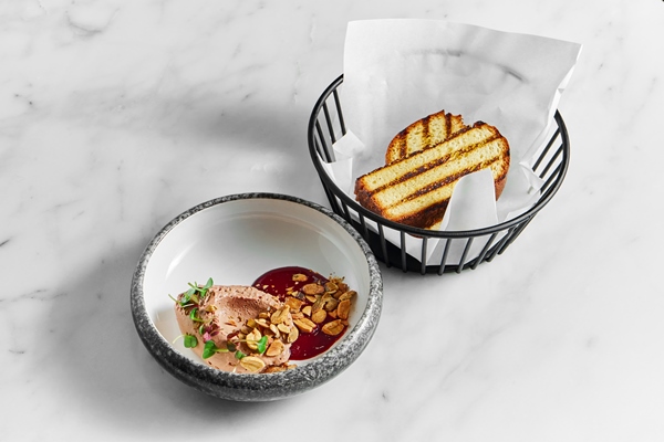 restaurant pate with berry sauce peanuts and microgrin in a marble plate with toast in a metal basket on a white marble background - Ягодная холодная приправа