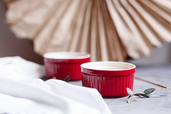 small glazed ceramic ramekin red baking cup for cupcakes muffins on a gray and white background ceramic baking dish - Картофельная запеканка с капустой и грибами в горшочке