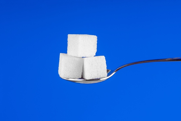 spoon with white sugar cubes on a blue background - Русский столовый хрен