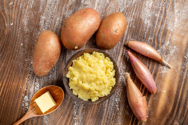 top view mushed potatoes with fresh potatoes on wooden desk meal ingredient color dough bake - Картофельная запеканка с капустой и грибами в горшочке