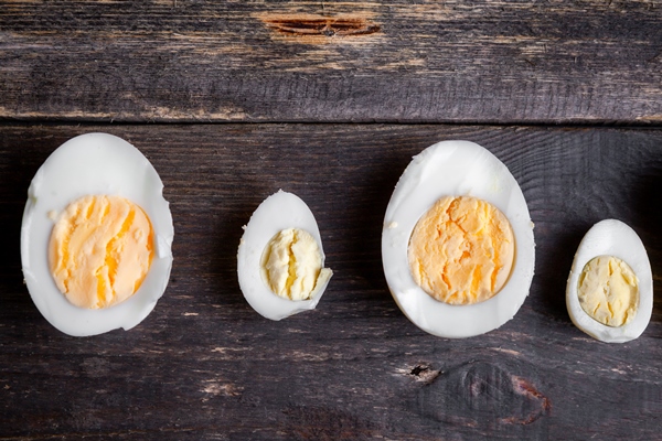 boiled eggs cut in a half on a dark wooden background top view - Французский соус эйоль (провансаль)