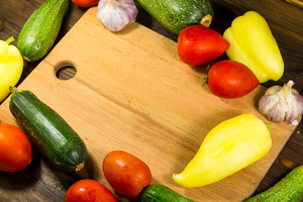 food frame with fresh organic vegetables tomatoes cucumbers pepper zucchini and garlic on wooden kitchen table healthy food concept - Турецкая запеканка с кебабом