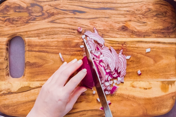 step by step slicing purple onion on a wood cutting board - Баранина по-индийски