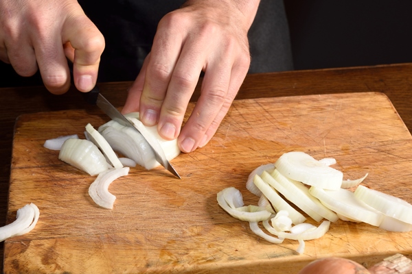 detail of a chef chopping onions - Печёночный пирог с морковью и луком