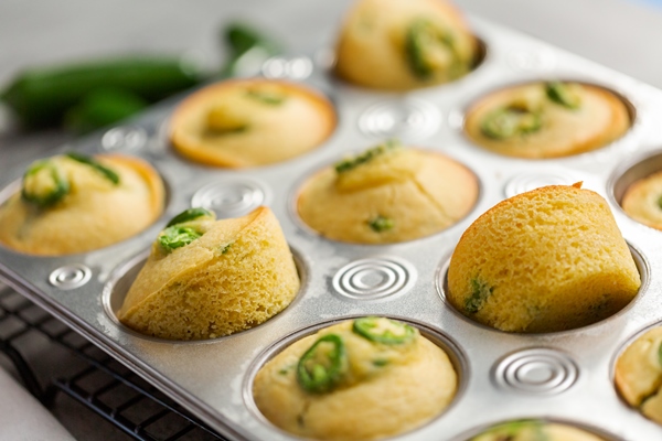 freshly baked cornbread muffins with spicy jalapeno pepper in muffin pan - Кукурузные маффины с халапеньо
