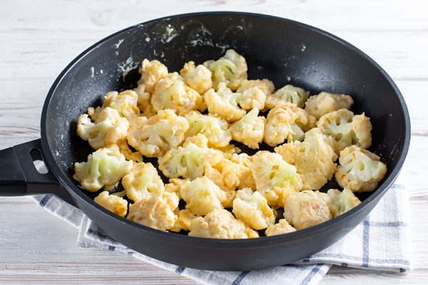 steaming roasted cauliflower florets in a frying pan cooking vegetables for a healthy vegetarian dish selected focus - Цветная капуста с яйцом и сыром