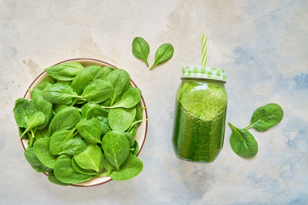 green smoothie from spinach and kale in glass jar and plate with fresh spinach copy space - Постный смузи-боул с огурцом, авокадо, спаржей и киви